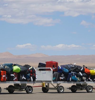 Călătorie Luggage carts at airport loaded with colorful bags under clear sky. Outdoor travel scene.