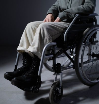 Sănătate și accidente An individual seated in a wheelchair dressed casually indoors, focusing on mobility and independence.
