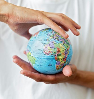 Sănătate și accidente Close-up of hands holding a world globe symbolizing global unity and environmental care.