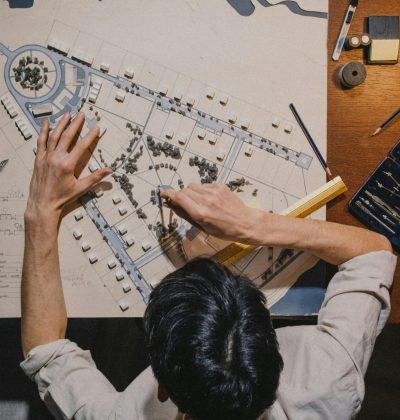 Răspundere civilă profesională Top view of an architect working on a design project with precision tools.